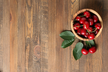 Fototapeta na wymiar ripe cherries in a wooden bowl on a wooden table