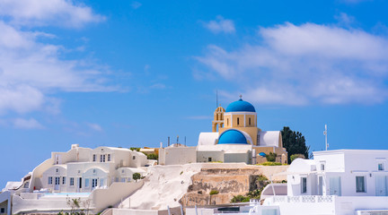 Fototapeta premium Santorini landscape with view of Agios Georgios Church and whitewashed houses in Oia, Greece