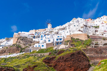Obraz premium Santorini landscape with view of whitewashed buildings and windmills in Oia, Greece
