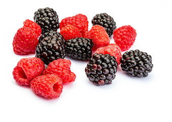 They look like artificial treats! But they are delicious and beautiful blackberries and fresh raspberries. Isolated on white background.