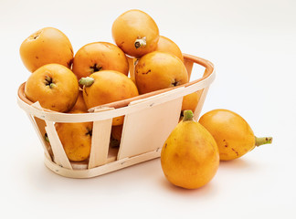 Fresh loquats (medlars) in wicker basket. Isolated on white background. Close-up.