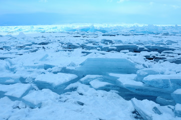 Field ice hummocks on the northern shore of Olkhon Island on Lake Baikal. Beautiful patterned cracks crawl across the surface of the ice. Ice Storm. Photo partially tinted.