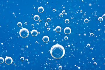 Bubbles of oxygen surging upward in blue water.