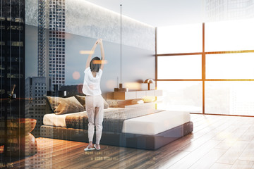 Woman in luxury gray bedroom