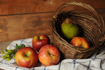 Still life with pear and red apples in a basket
