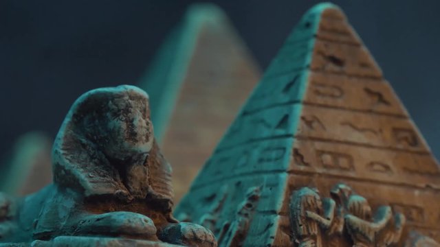 Closeup on an old sphinx and pyramid relic with fog around it.
