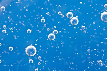 Bubbles of oxygen surging upward in blue water.