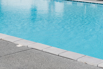 Edge of swimming pool with blue water
