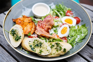 Chicken ceasar salad. Chicken, pancetta, eggs, tomatoes with garlic bread with caesar sauce. 