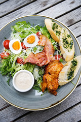 Chicken ceasar salad. Chicken, pancetta, eggs, tomatoes with garlic bread with caesar sauce. 