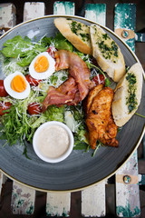 Chicken ceasar salad. Chicken, pancetta, eggs, tomatoes with garlic bread with caesar sauce. 