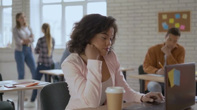 attractive girl carefully looks into the computer waiting for the message. girl refreshes the page and yawns. 4k