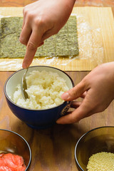 The process of preparing sushi from rice and additional ingredients at home