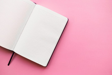 top view of an open notebook on a pink background. flat lay, copy space