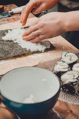 Foto op Canvas The process of preparing sushi from rice and additional ingredients at home © Niko_Dali