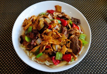 Tranditional dish of Central Asia Moghuru Lagman, made of pulled noodles, meat, vegetables and mushrooms