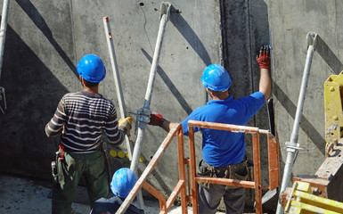Des ouvriers posant des étais sur le chantier d'un immeuble en construction