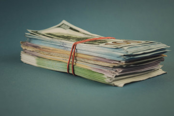 Credit cards and a bundle of money on a plain blue background.