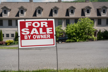 Fototapeta premium Blank for sale by owner sign in front of a row of town houses or homes in the USA