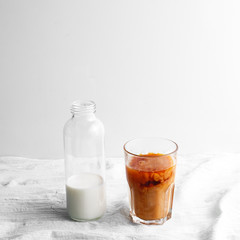Bottle with milk and glass cup with coffee on the table. cold brew iced coffee