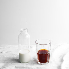 Bottle with milk and glass cup with coffee on the table. cold brew iced coffee