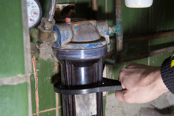 Men's hand trying replace old water filter