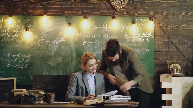 Bearded tutor helping his student. Teacher couple. Teacher helping his students with math or mathematics on education class. Classmate Classroom Sharing International Friend Concept. Learning concept.