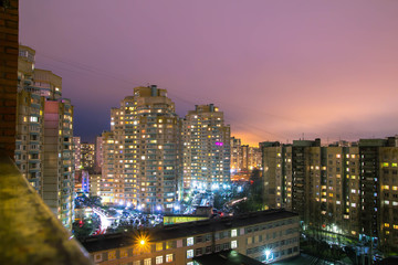 Glowing and sparking lights of night city neighborhood, big tall residential buildings illuminated by light from windows at nights streets, cityscape.  Night sleeping area of Saint Petersburg, Russia