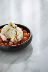 Burrata Büffelmozzarella Kugel mit Tomaten, Olivenöl und Balsamico auf schwarzen Teller