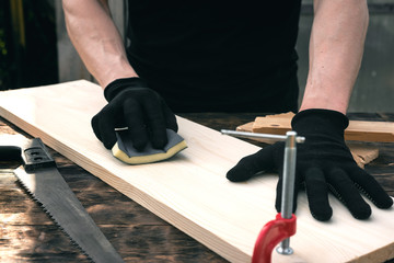 Worker polishes a wooden board. Woodwork. Carpentry.