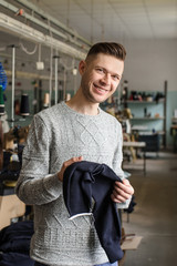 close up photo of a young man analyzing the work at the linking machine for knitting in textile industry