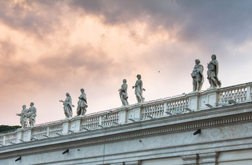 Roof of Saint Peter's Cathedral in the Vatican with various statues and sculptures on it, columns...