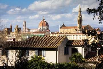 Fototapeta na wymiar Amazing view on Florence city and its main cathedral dome (Santa Maria del Fiore dome) and Santa Croce tower. Awesome cityscape of Florence roofs, Italy. Old residential cute house on the foreground.
