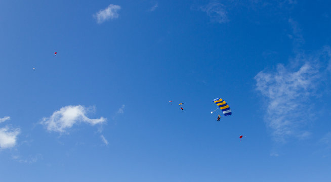 Silhouette Of Sky Divers Flies Back To The Ground After A Tandem Skydive, Byron Bay, Queensland, Australia