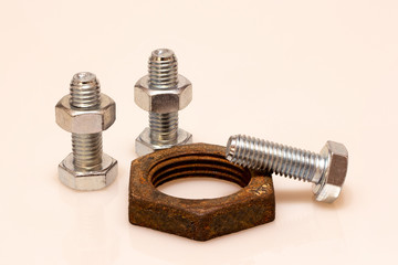 Two new bolts with nuts and one new bolt with an old rusty nut of another size