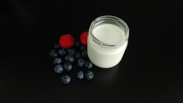 White Yogurt with Berries on a black tabletop