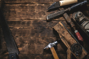 Old construction tools on a wooden workbench flat lay background with copy space. Carpenter table. Woodwork.