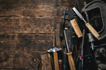 Various old construction tools on a wooden workbench flat lay background with copy space. Carpenter table. Woodwork.