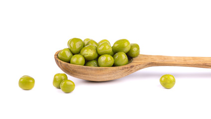 Green peas in a wooden spoon, isolated on white background. Pickled peas. Canned green peas.
