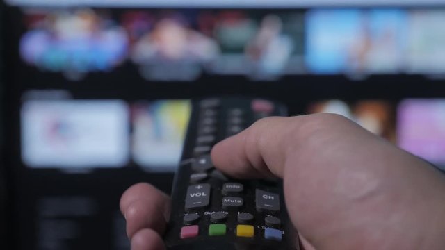 smart tv. online video streaming service. with apps and hand. Male hand holding remote the control lifestyle turn off smart tv. man hand controls holding remote. concept internet online cinema