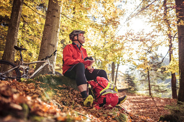 Man with mountain bike resting in forest