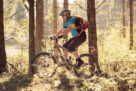Man riding mountain bike on forest track