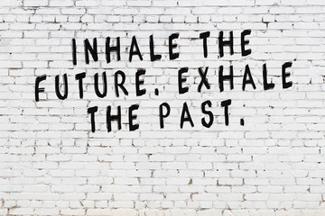 White brick wall with painted black motivational quote inscription