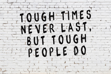 White brick wall with painted black motivational quote inscription