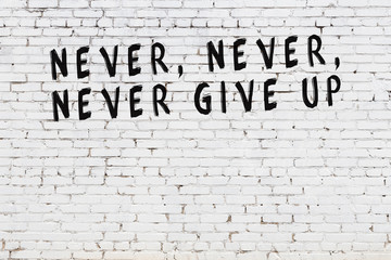 White brick wall with painted black motivational quote inscription