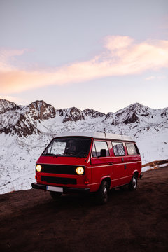 Red caravan riding near snowy mountains