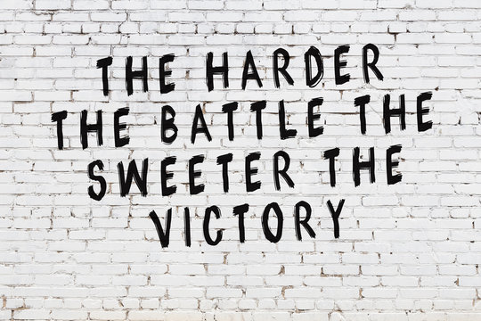 White brick wall with painted black motivational quote inscription