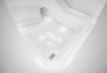 From above of perspective contemporary illuminated stairway in white color going spiral