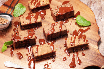 Brownie dessert. Cake chocolate brownies on wooden background with mint.