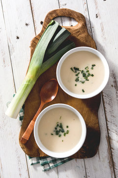 Shoot from above of two bowls of tasty Vichyssoise soups on wooden table with leek